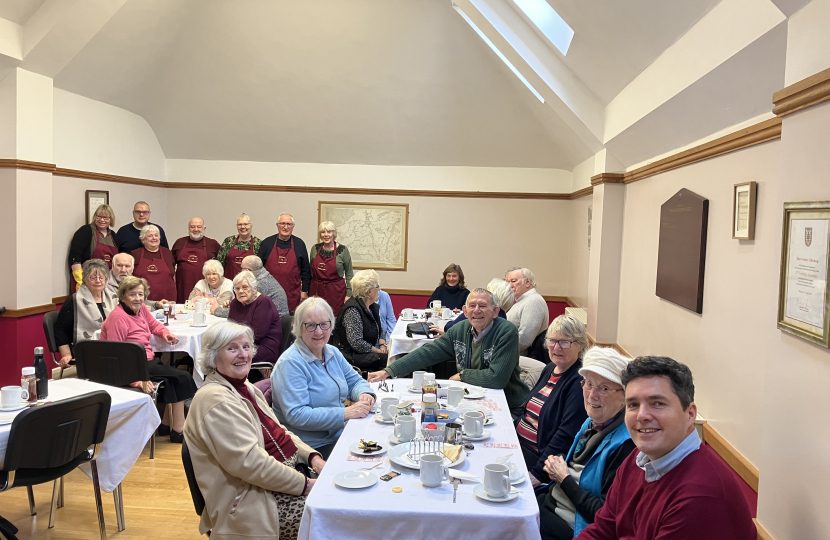 Huw sat at table with breakfast club members and volunteers