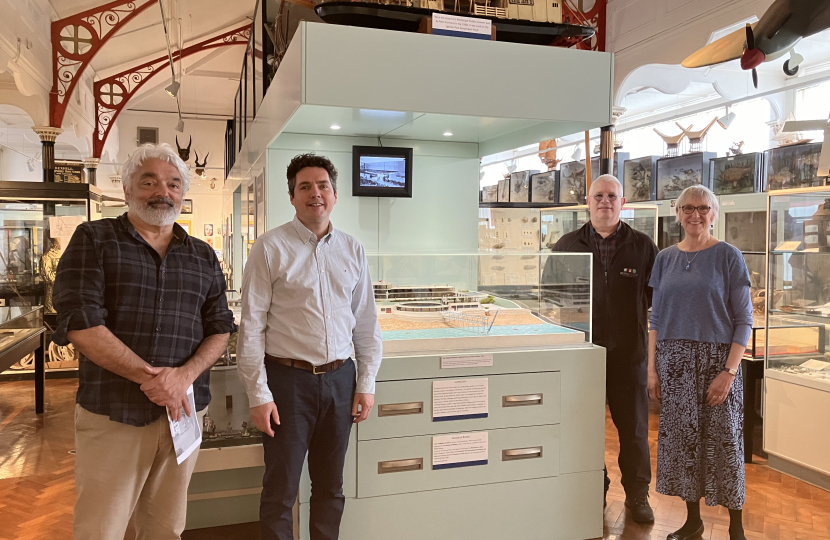 Huw standing in Bexhill Museum in front of model of De La Warr Pavilion with Rohan, Sally and Julian