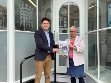 Photo of Huw and Christine Bayliss holding Bexhill bus survey document