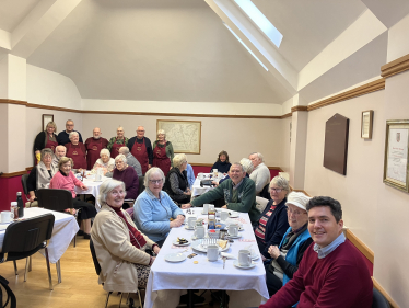 Huw sat at table with breakfast club members and volunteers