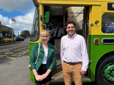 Photo of Huw and Sarah in front of bus