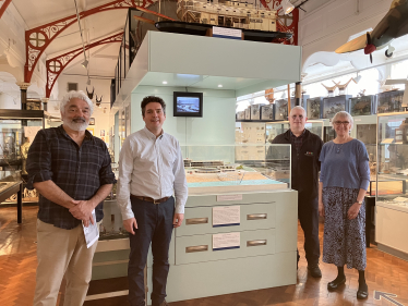 Huw standing in Bexhill Museum in front of model of De La Warr Pavilion with Rohan, Sally and Julian